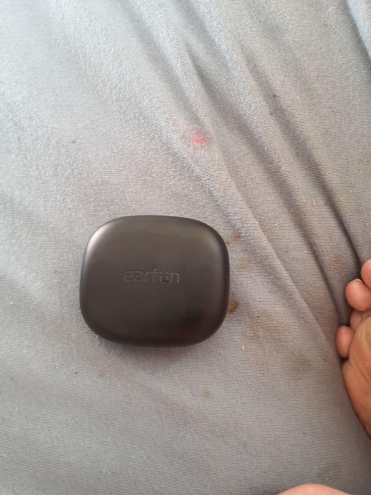 Picture of black EarFun Open jump headphones lying on my bed 