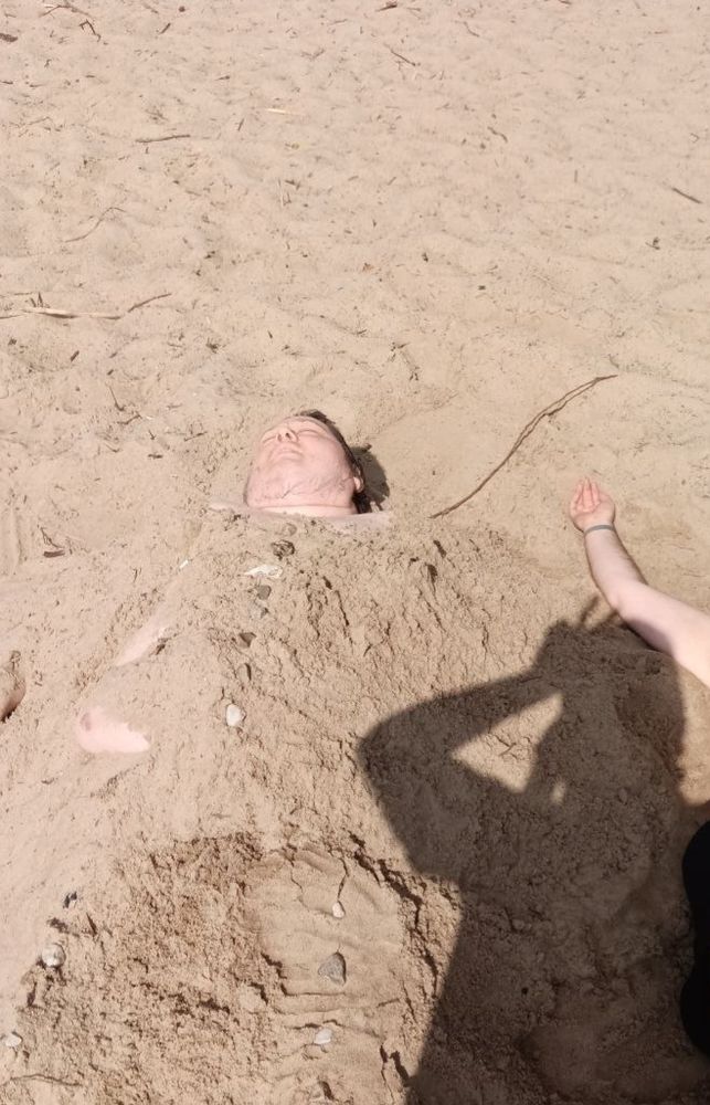 A photo of me where I am completely covered in sand except for my face