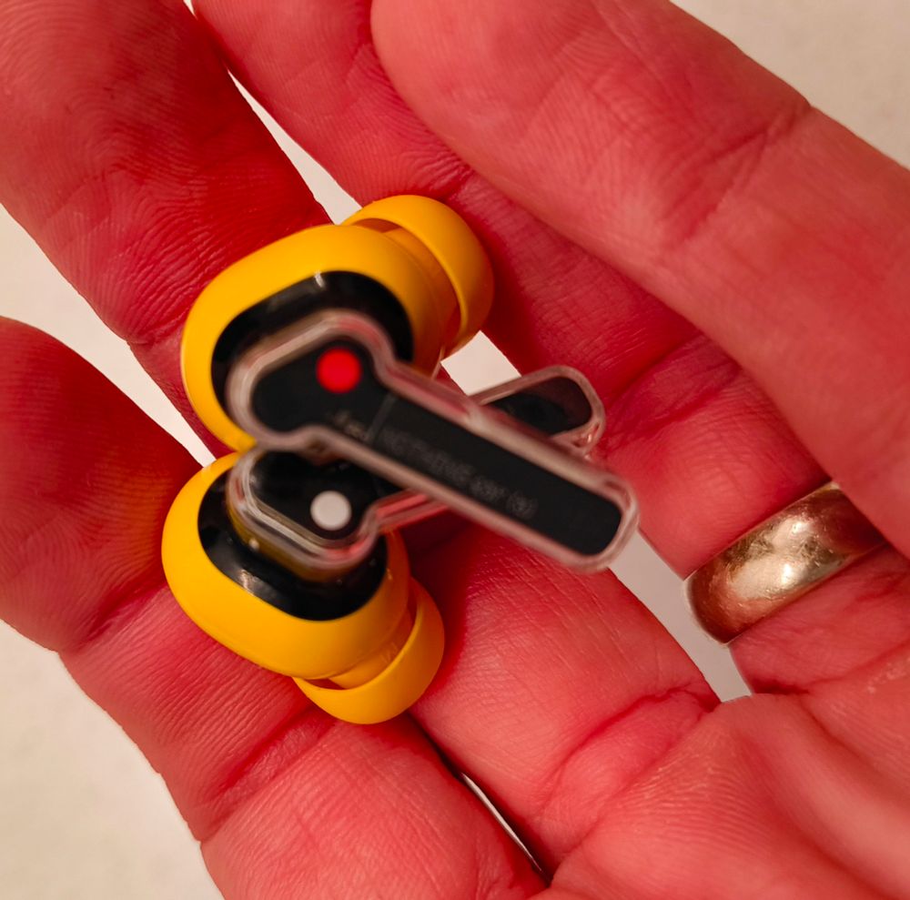 A pair of nothing 2a earbuds showing the white and red dots