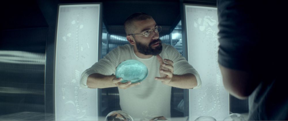 Ex Machina (2/4) Nathan holds a clear bluish brain-sized artwork that acts as Ava’s brain, explaining it