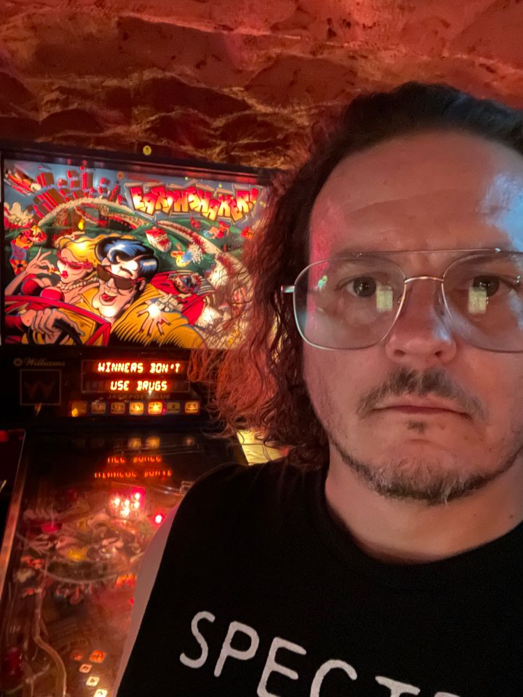 Selfie in front of a pinball machine displaying the message “winners don’t use drugs”