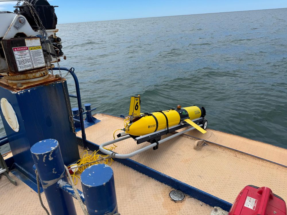 An glider placed on the deck of a boat, ready for deployment in open sea waters.