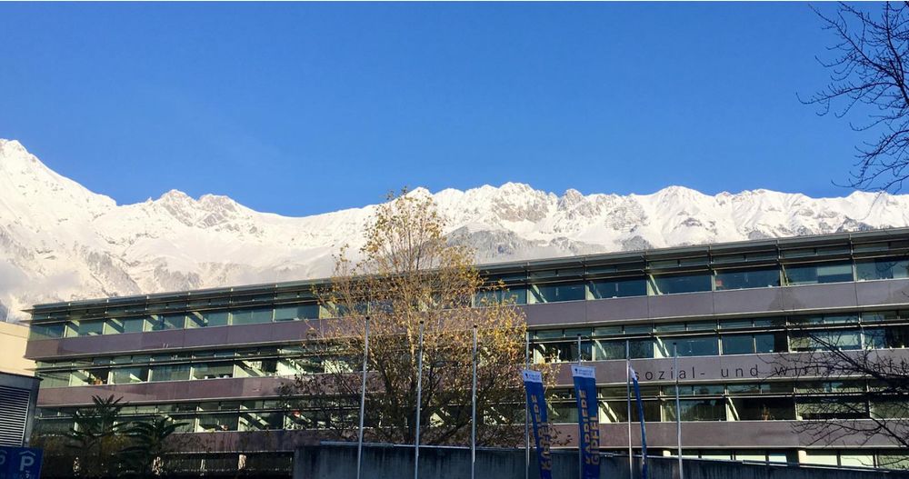 University building in Innsbruck, Austria with snowy mountain peaks