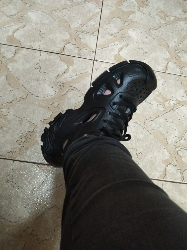 Un pie calzado con un zapato híbrido entre Crocs y tenis.