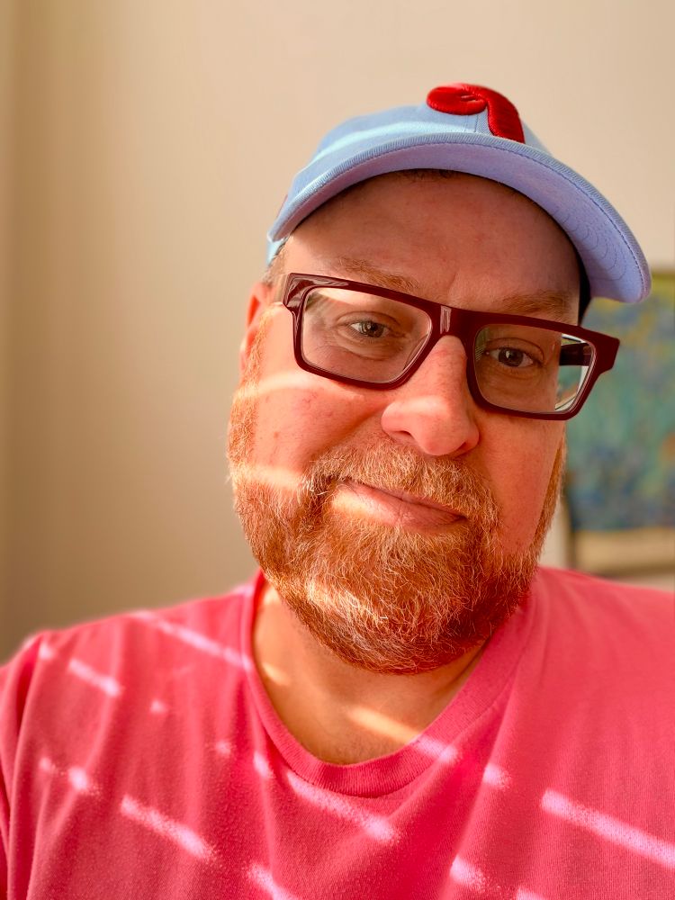 A selfie, pink shirt, blue Phillies 🧢 on.