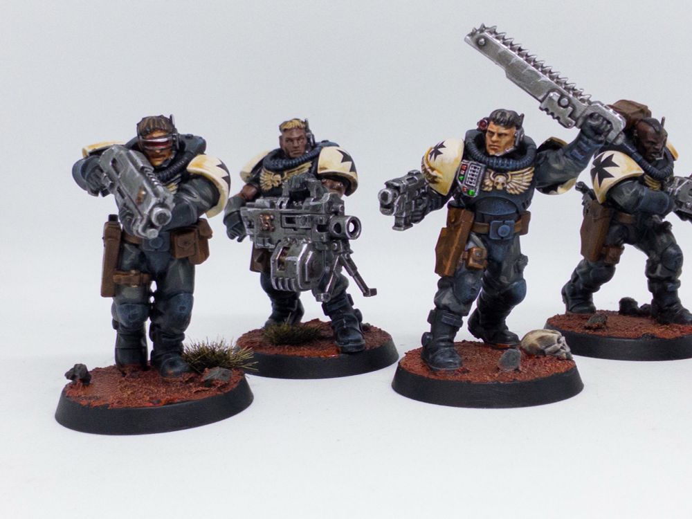 (Accessibility: photos of games workshops Warhammer 40,000 Space Marine scout miniatures painted in the black and white heraldry of the Black Templars chapter, on Martian red themed bases. Photographed against a white light box background.)