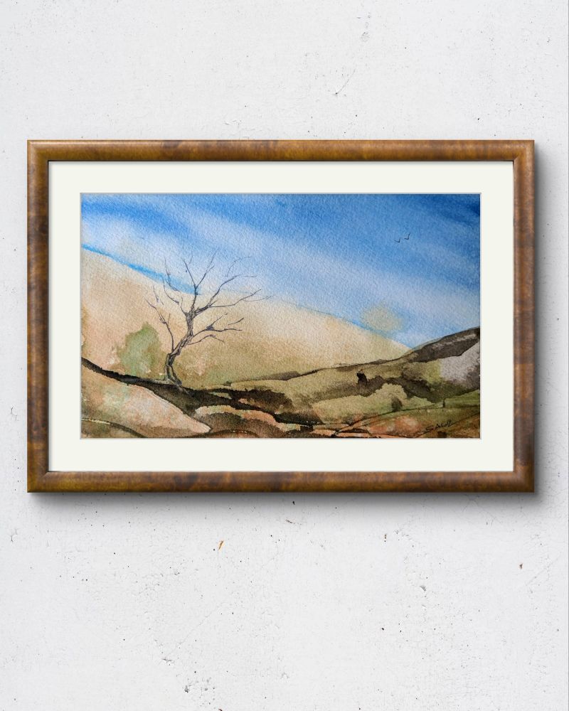 Framed watercolour of a landscape with distant sand dunes and some sparse vegetation in the foreground. 