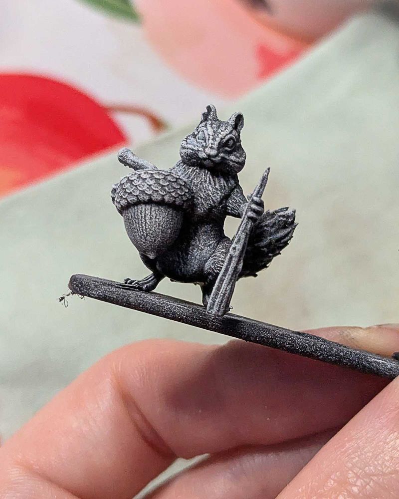 Miniature d'un tamia qui tient un gland et un grosse épine pour se défendre. 