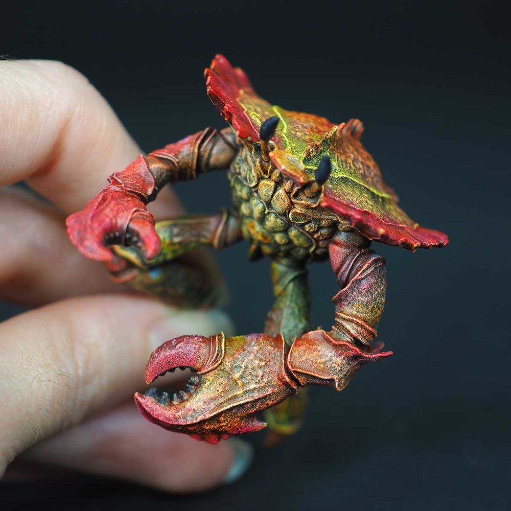 Figurine de crabe mutant, peinte en rouge et jaune.