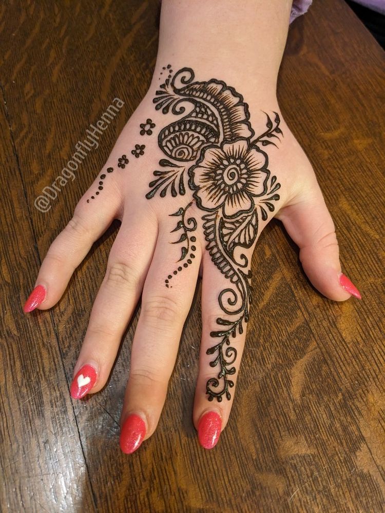 Hand with manicured nails and an original floral henna design, paste on.