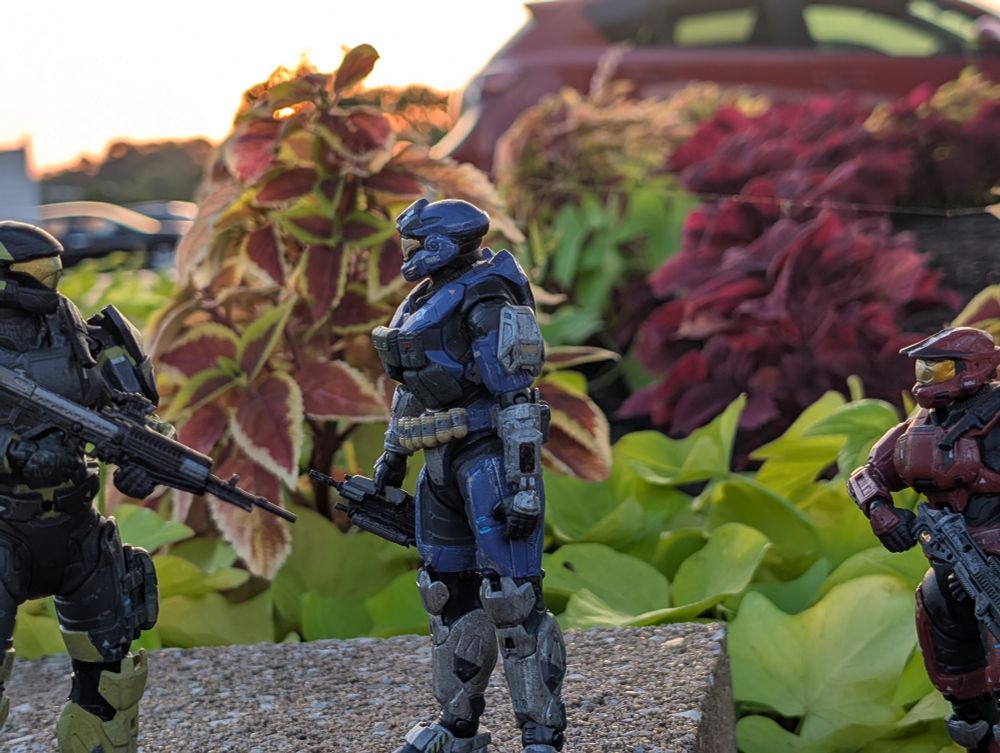 Three Halo Spartans in front of some plants, one looking pensively off into the distance. 