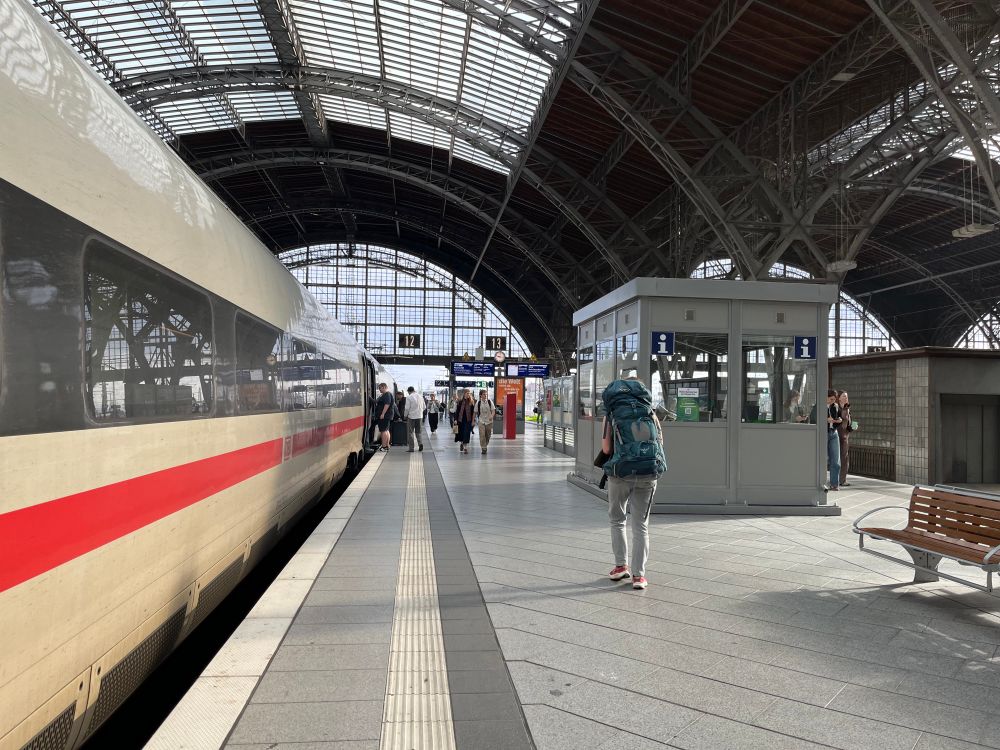A German fast long distance train in a train station with passengers boarding it.