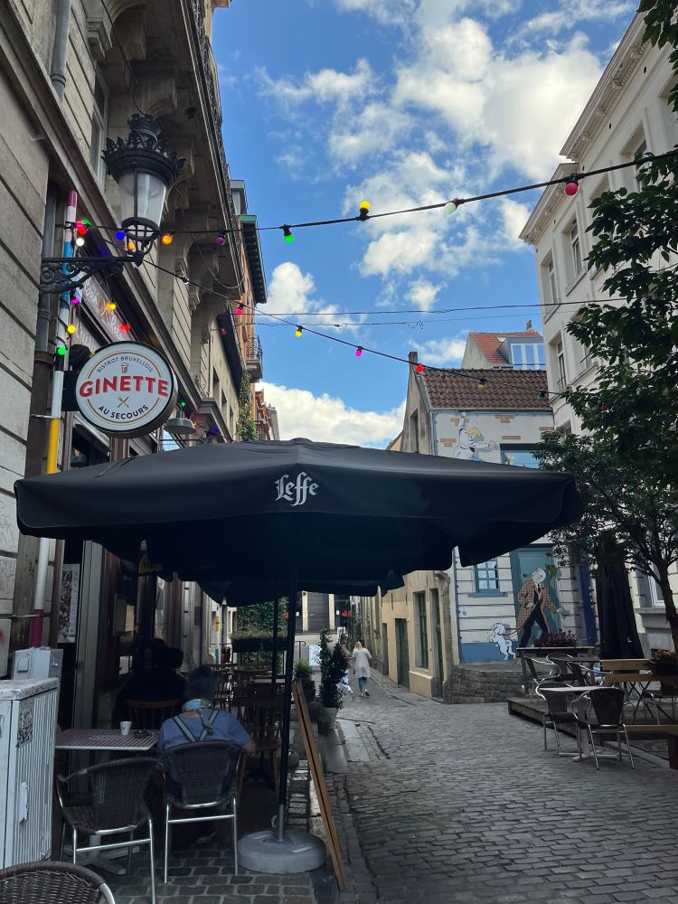 A street with chairs and tables from a restaurant outside