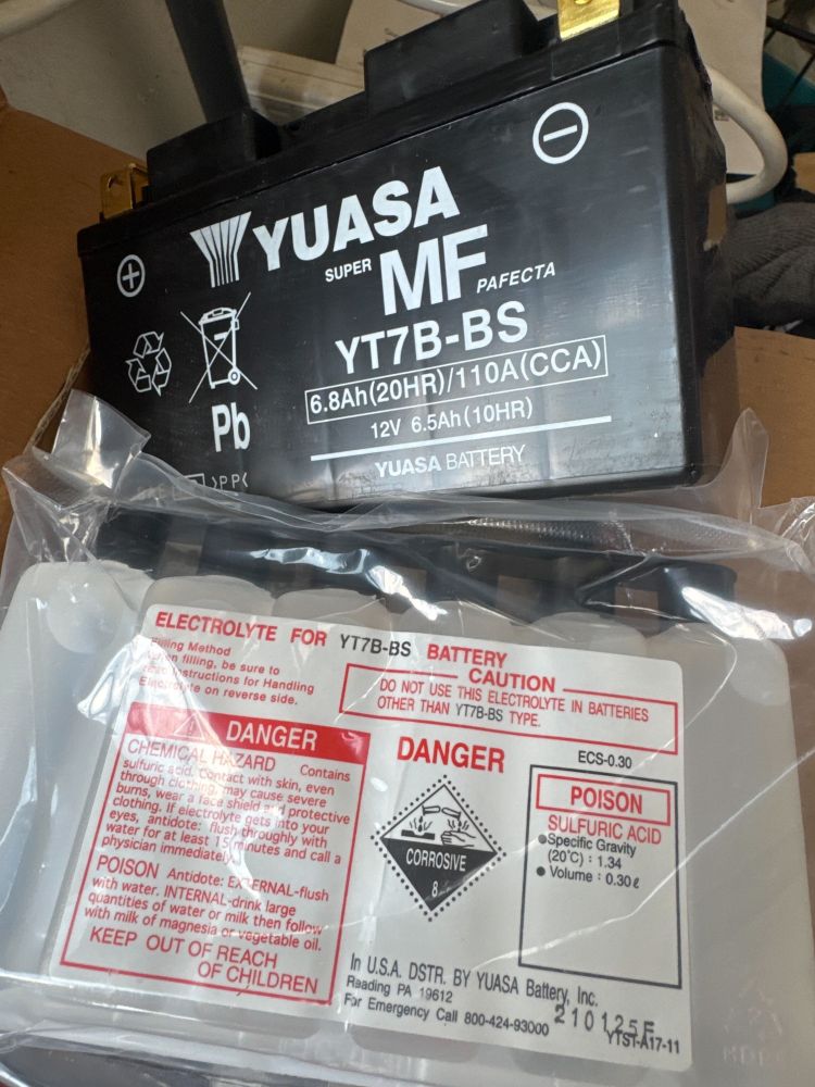 a Yuasa motorcycle battery as shipped, dry with the electrolyte in bottles for assembly at home