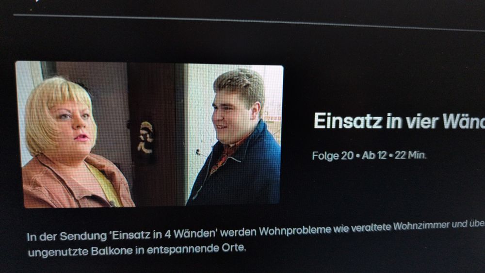 Auf einem Screenshot von RTL+ ist eine Szene der Sendung „Einsatz in vier Wänden“ zu sehen. Links steht eine Frau mit blondem Bob und brauner Jacke, rechts ein junger Mann mit kurzem Haar und dunkler Jacke. Daneben steht der Sendungstitel und die Folgeninformationen.
