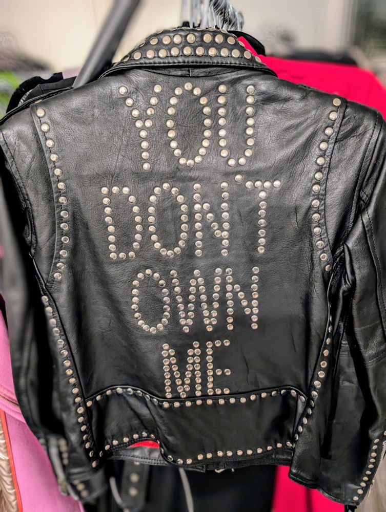 A studded leather jacket that reads "You Don't Own Me" on the back.