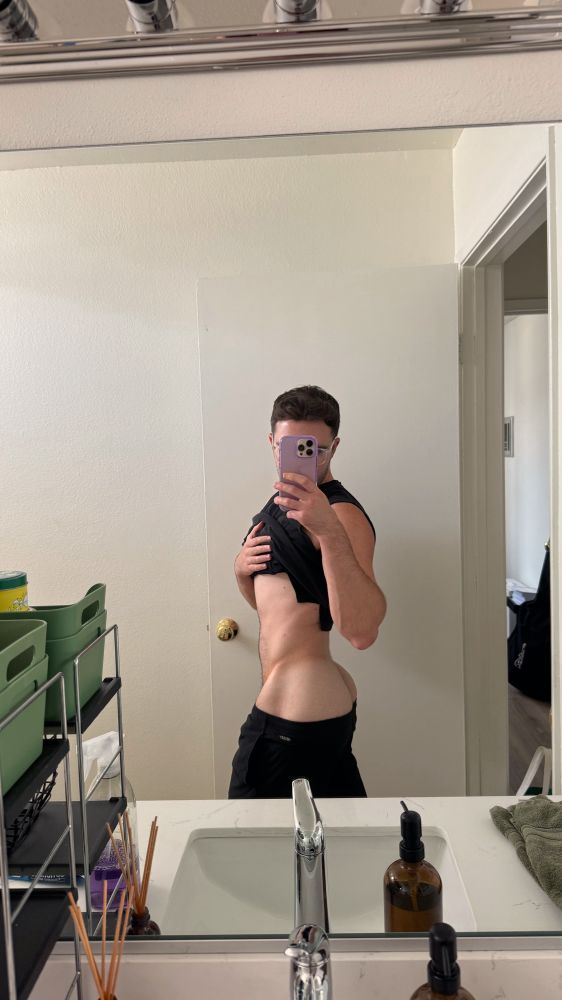 user is posing in the mirror in side profile with slight booty exposure.  again !!