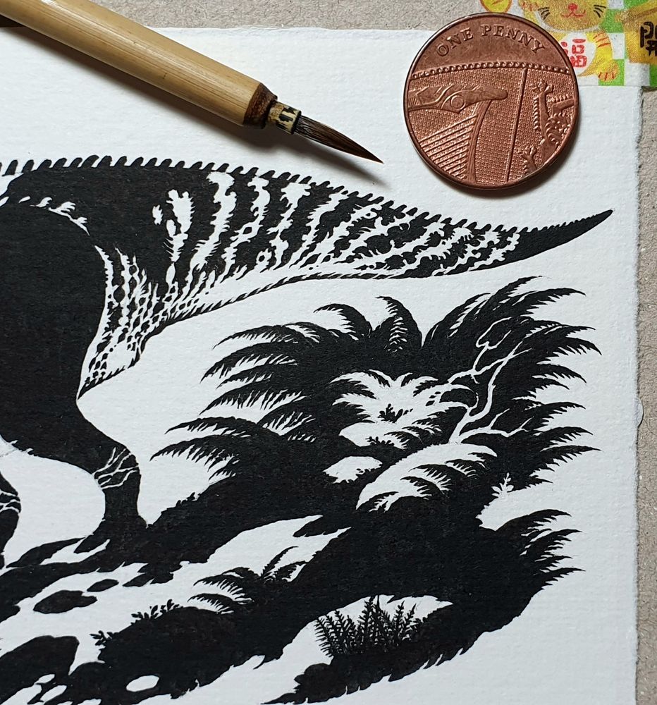 Detail from a work in progress of the tail of a hadrosaur and some foliage drawn in black ink. The piece is primarily in silhouette, with the negative shapes of the white of the paper showing through in details such as the dinosaur's markings. The piece is very small and intricate.