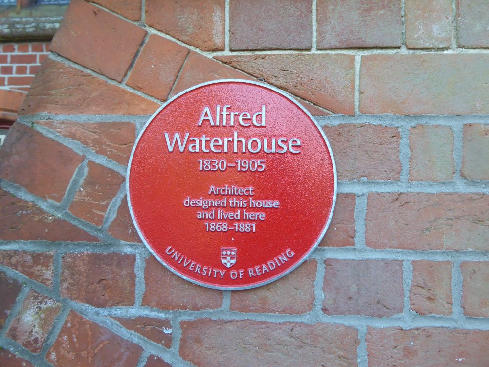 A red plaque fixed to brickwork reading "Alfred Waterhouse, 1830 - 1905, Architect...designed this house and lived here 1868 - 1881"