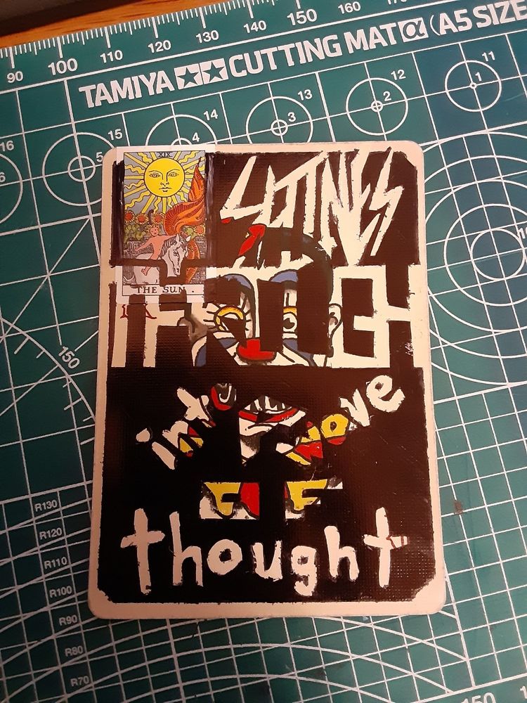 stencilled in song lyrics and a sticker on a playing card- the lyrics read "The sun shines through into a wave of thought", from the song Her and I (Slow Jam 2) by King Gizzard and the Lizard Wizard