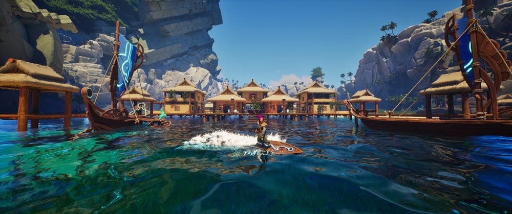 Screenshot of my character on the Founder's Pack skimmer, surfing in front of a base that I built. It resembles a Polynesian village. The Founder's Pack cargo skiff is also in the shot. It has wood accents and a blue sail, all with glowing accents.