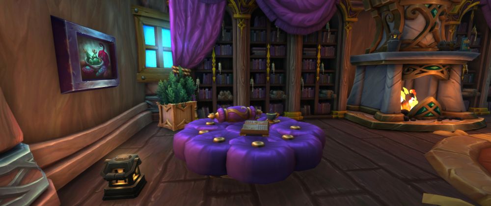 Screenshot from housing beta in Warcraft. Shows an ottoman I made with several pillows, a painting on the wall, bookcases with drapes, s fireplace, a planter, and a lantern.