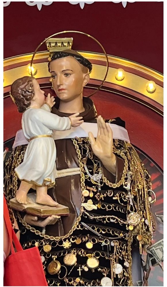 Close-up of the St. Anthony if Padua statue. People who have had their prayers answered pin jewelry or money to the statue to say thank you to the Saint. Anthony is the patron saint of lost items, domestic pets, finding a mate, brides (when he was a monk he often provided a dowry so poor women could marry), the elderly, and good harvests, to name a few.
