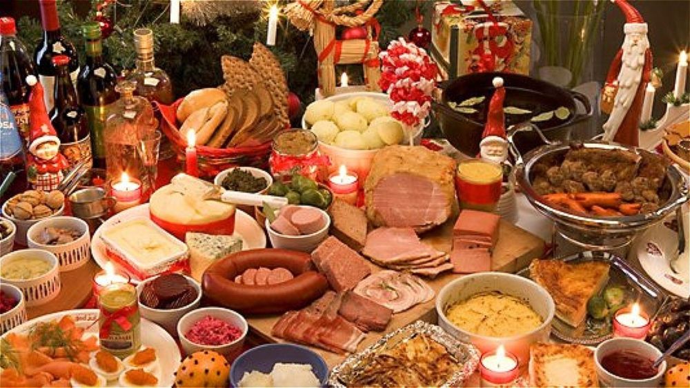 An extraordinary smörgåsbord of assorted meats, cheeses, vegetables, fruits, breads, and more, accompanied by Swedish carved Santas and straw goats. 