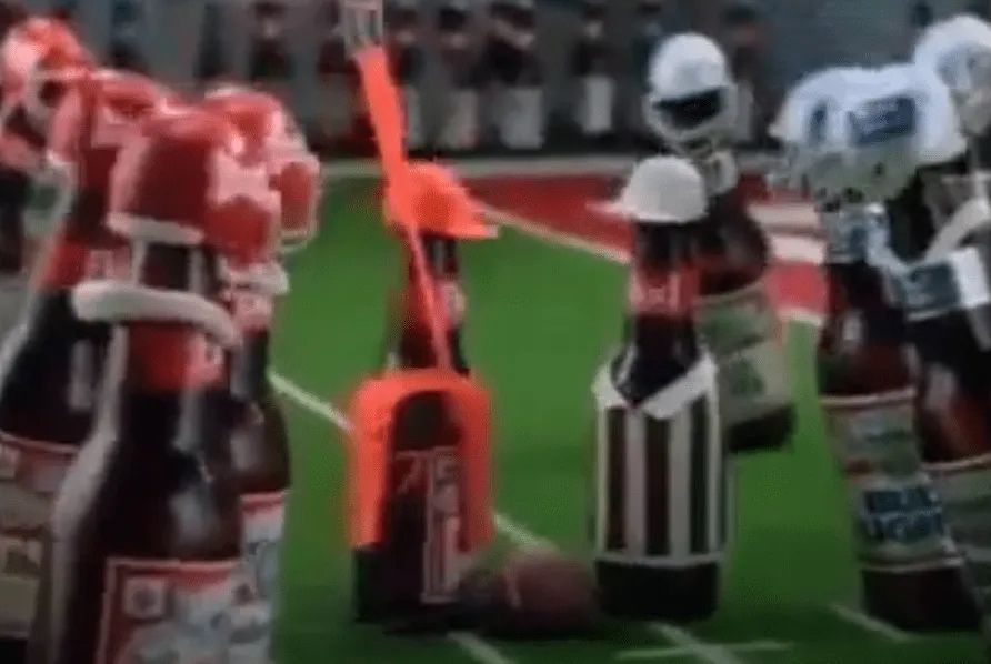 A fucking goddamn Budweiser referee measures for a first down while the two teams watch on in anticipation. Feels like the Budweiser ref crew might be a bit biased, but again, hard to say for sure from a single photo. 