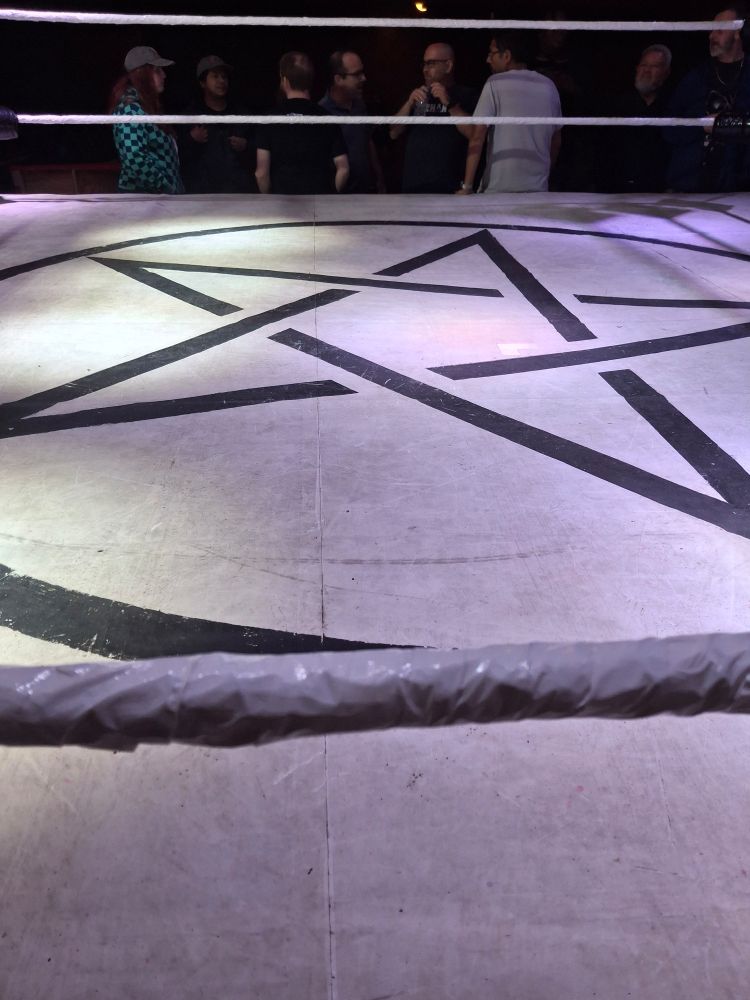 A wrestling ring with a pentagram in the center 
