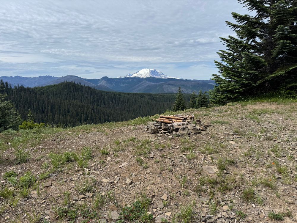 A fire ring in the foreground and Mount Rainier in the background