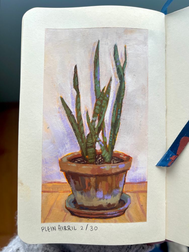 Holding a sketchbook open to show you a painting of a snake plant in a large pot