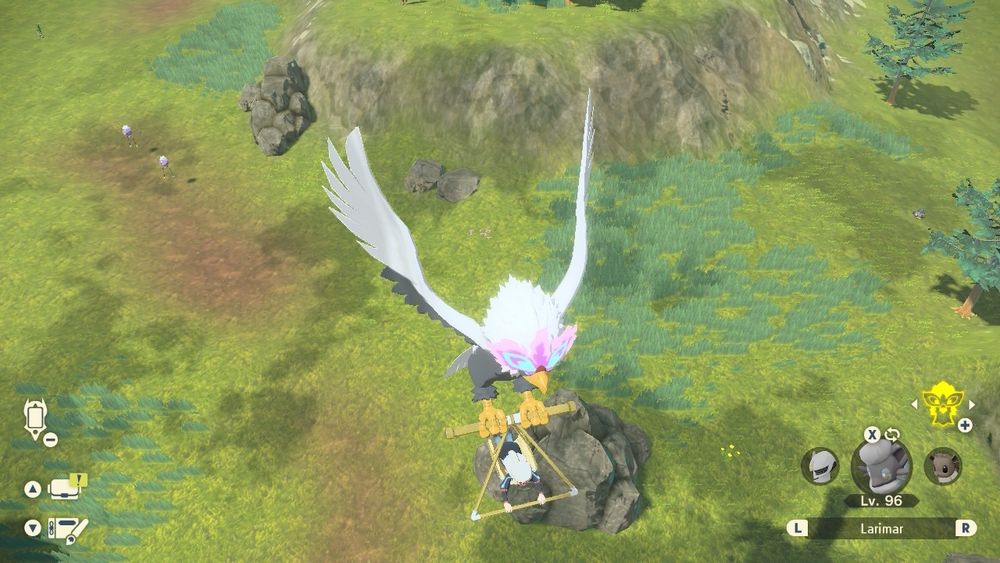 A screencap from Pokemon Legends Arceus showing the trainer hovering in the air with Braviary over a small clearing with rocks and trees. Two Drifloon are to the left and a single Starly on the right