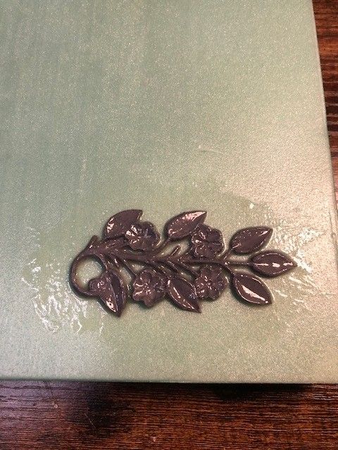 Close up of a grey 3D floral motif, which has been applied to a foam panel and then coated with clear epoxy.