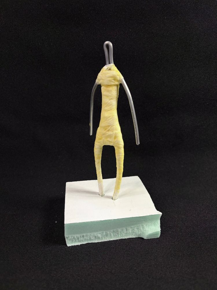 In-progress armature of a small sculpture, showing the wire and paper mache.