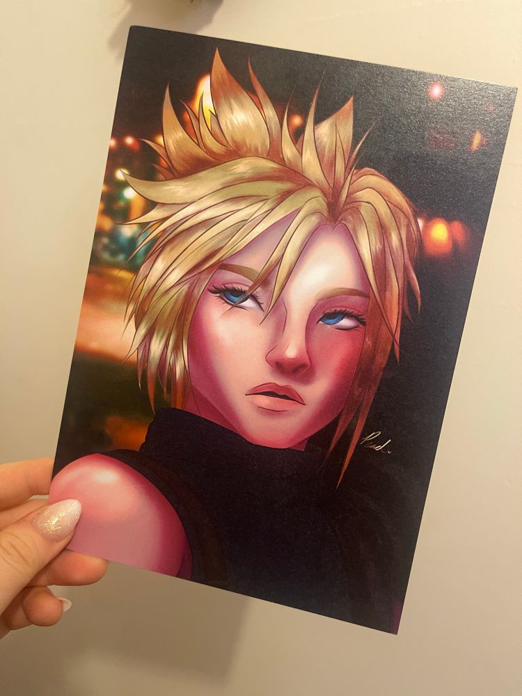 A hand holding a print of Cloud Strife from Final Fantasy 7. It is a bust-up digital piece of cloud looking over his shoulder.
