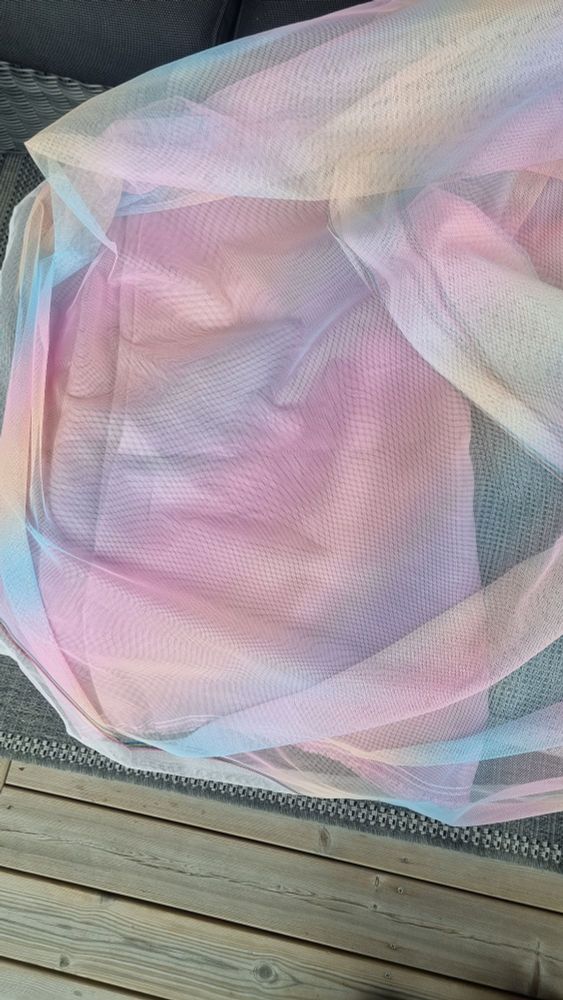 The tulle is here draped over the pink, showing how the pink and tulle appears together, since the tulle is partially see-through. 
