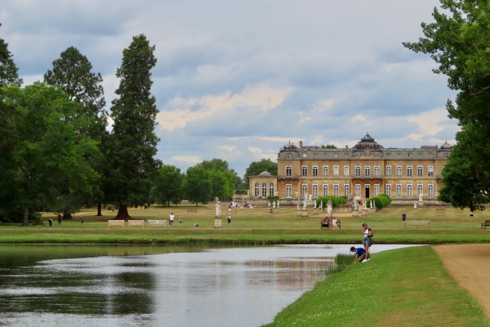 The house at Wrest Park, viewed from beside the long water. There are many statues and people enjoying the grounds, you can usually tell which is which.