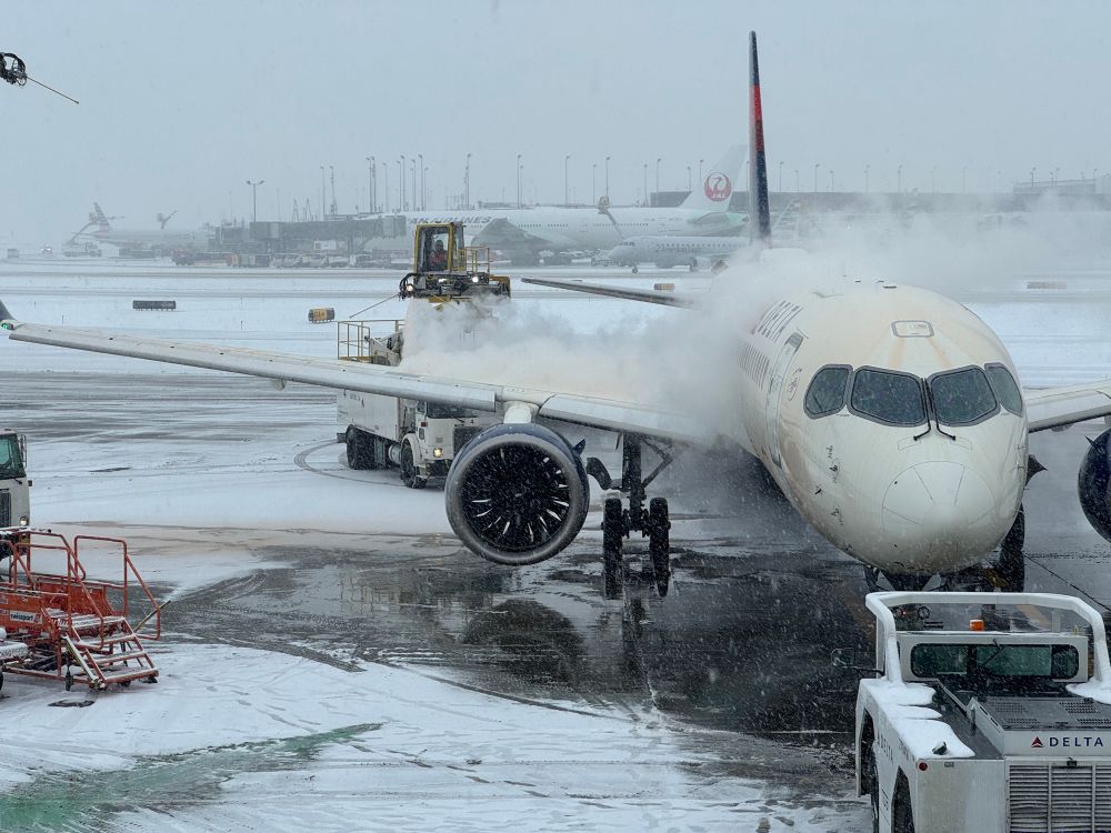 Delta aircraft being de-iced at O'hare. Lots of snow and slush around. 
