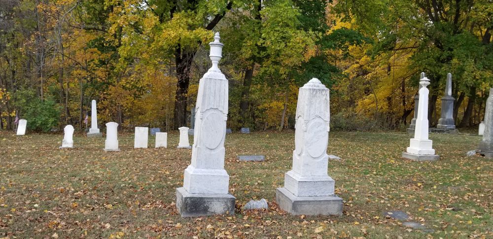 A pair of matching tombstones but one has the top missing 