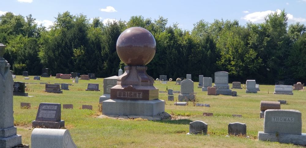 A grave stone with a big sphere on top I love graves like this. We need more stuff like this with some character in cemeteries. Fun fact there's the grave like this in Marion Ohio where the sphere won't stop spinning 