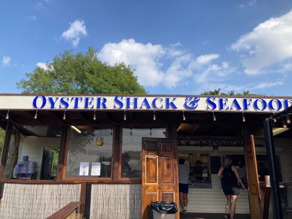 A small building labelled Oyster Shack & Seafood in bold blue font