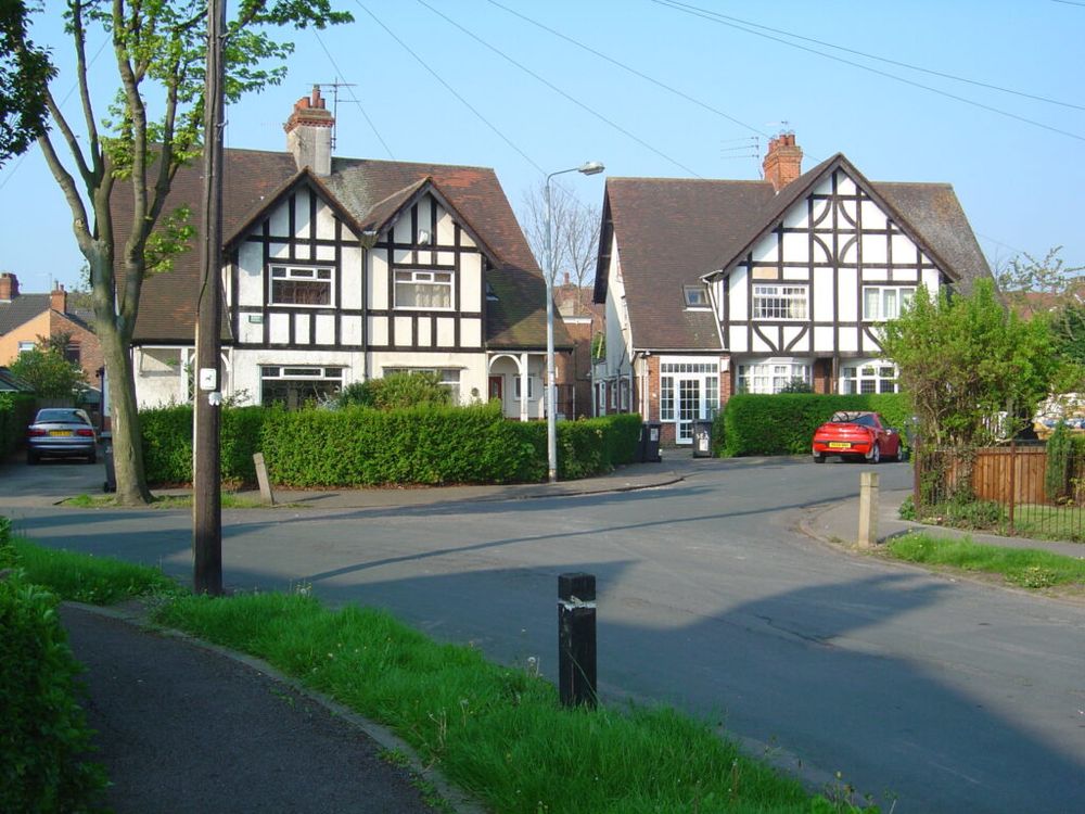 The Broadway Conservation Area. Image shows semi-detached houses with white fronts and black timber in a residential street. 