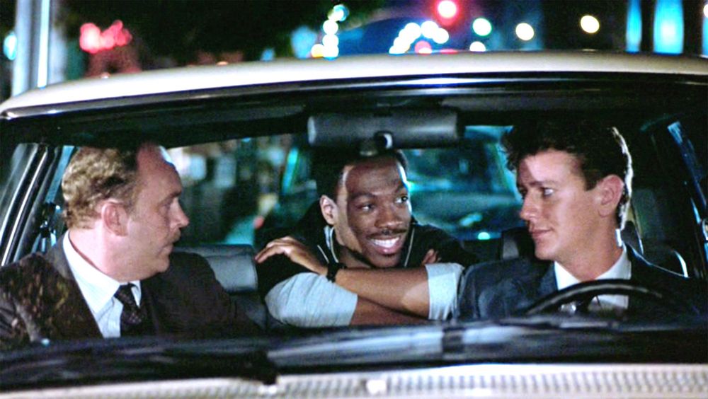 Black actor Eddie Murphy and his two white sidekicks in the police propaganda movie Beverly Hills Cop.