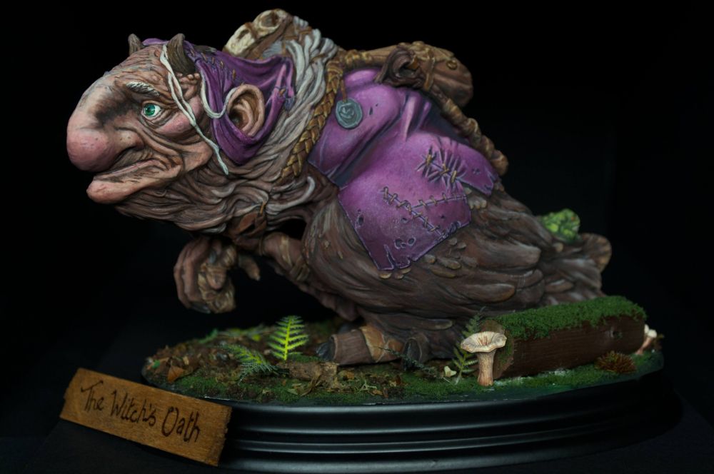 A witch with Dark Crystal vibes, feathers, fur and a big nose.