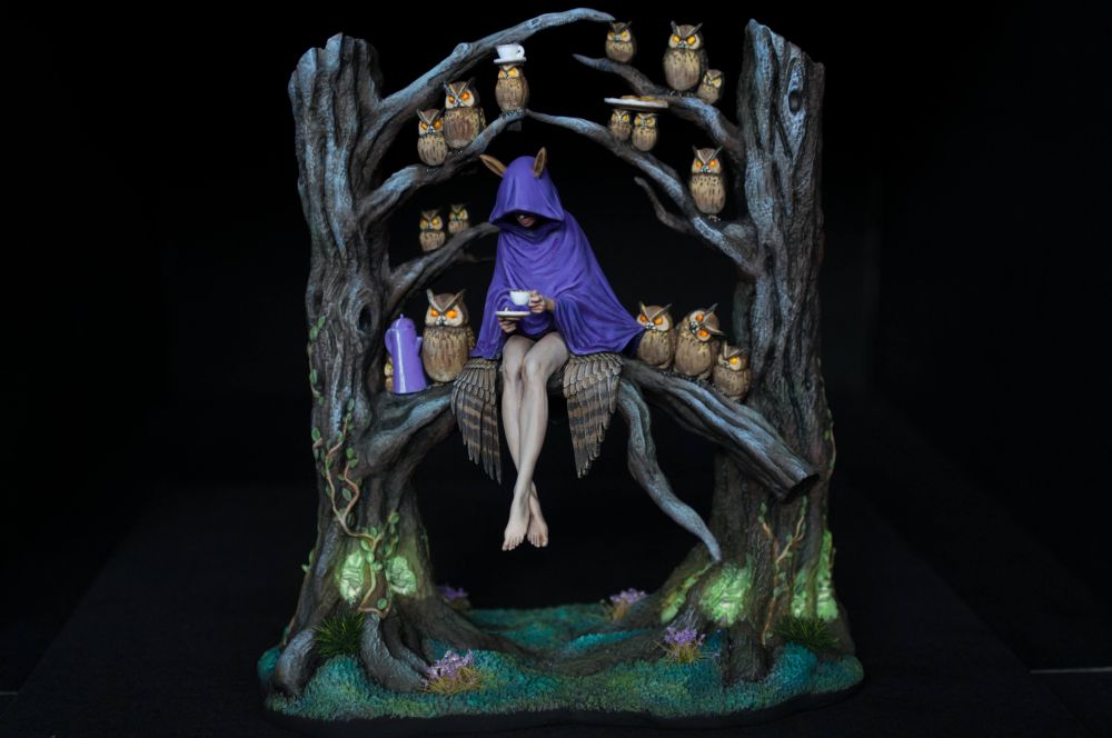 Tea party, a fairy or nymph sits in tree surrounded by owls, drinking tea.