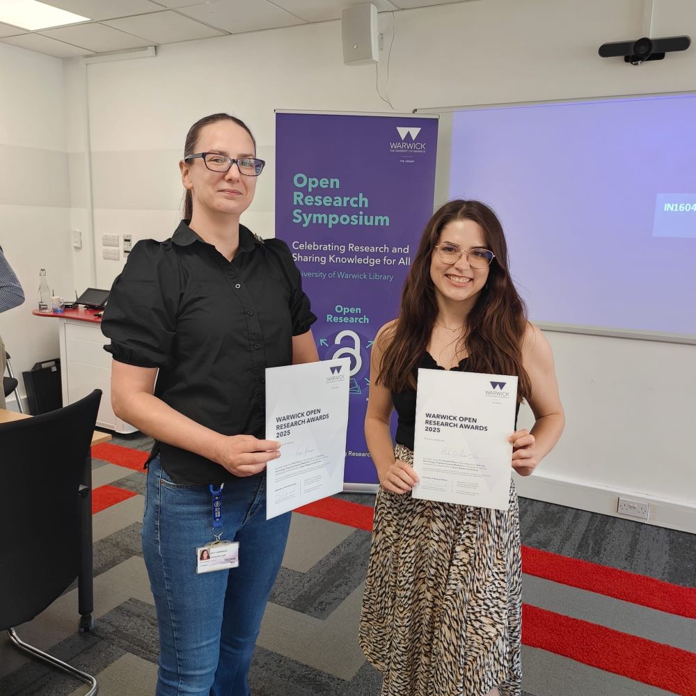 Two women holding certificates and smiling.