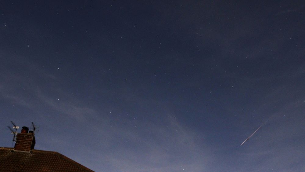 A orange Perseid meteor near the Plough asterism in Ursa Major, captured on 12 August 2022 at 23.19 UT. The sky has a blueish colour due to light from the nearby Moon.