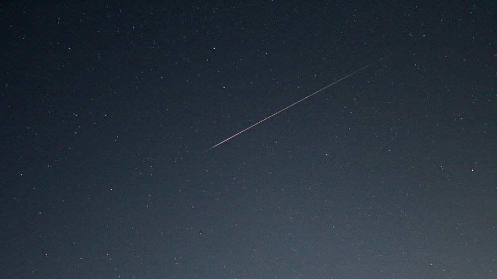 A green and orange Perseid meteor flashing amongst the stars of Draco and Hercules at 23.54 UT on 12 August 2025. Settings: Canon 550D and 18mm lens at 13s exp, 18mm fl, f/3.5, ISO-800.