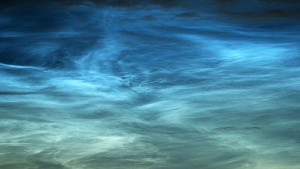 A close-up shot of the noctilucent clouds display on 29-30 June 2025, showing the varied forms and blue hues of these unique clouds. Taken with a DSLR and 300mm lens.